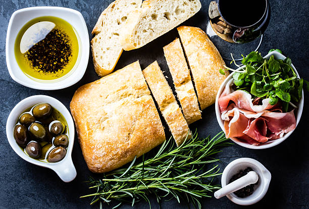 istock Ciabatta, pepper oil, jamon ham serrano, arugula, rosemary, slate background 620706468