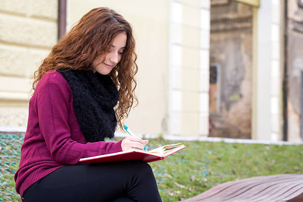 istock young school girl writing on an notepad with a pen 620712530