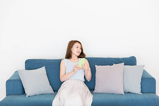 istock Japanese woman sitting on the sofa 620714668