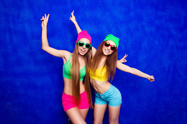 istock Two trendy women in hats dancing on blue background 620714942