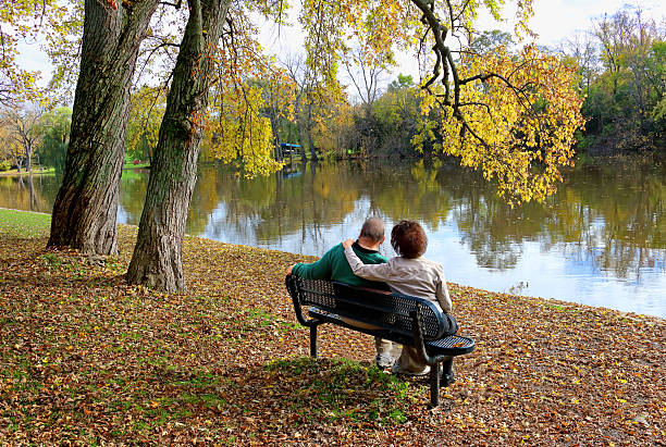 istock couple sitting on outdoor bench in autumn 620716974