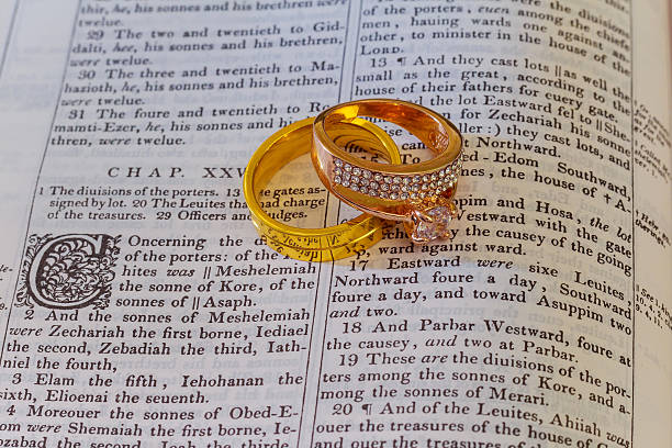 istock Wedding rings place on an open Bible  verse  book 620718904