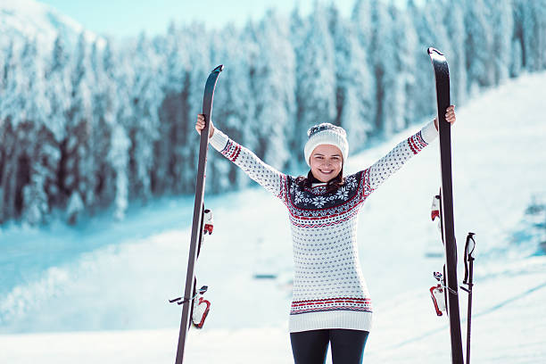 szczęśliwa narciarka z podniesionymi nartami na śniegu - on top of mountain peak success cold zdjęcia i obrazy z banku zdjęć