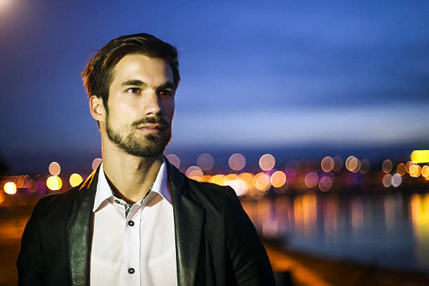 Attractive man on a city street at night. About 25 years old, well-dressed Caucasian male.