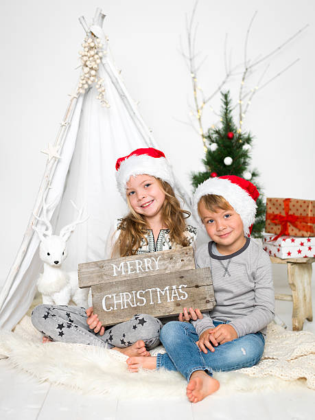brother and sister with Christmas hat brother and sister with Christmas hat love roe deer stock pictures, royalty-free photos & images