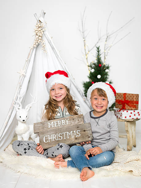 brother and sister with Christmas hat brother and sister with Christmas hat love roe deer stock pictures, royalty-free photos & images
