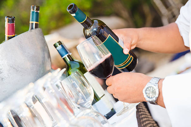 Male sommelier pouring red wine
