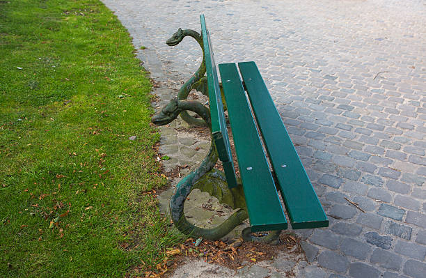 empty park bench with dragon head decoration at brugge belgium