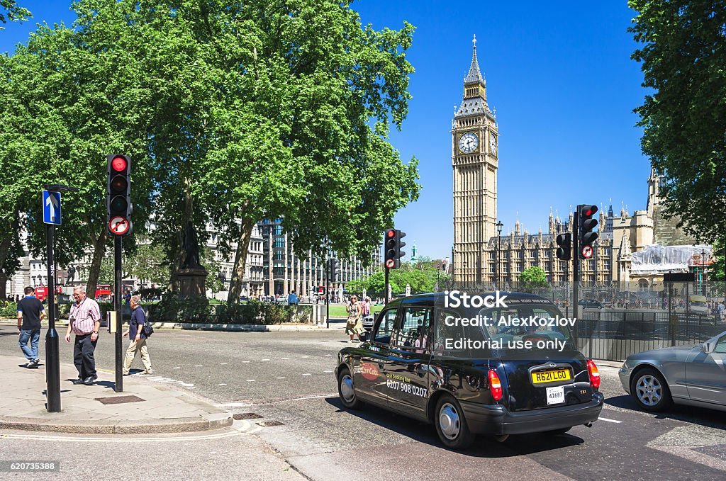 Black taxi cab in front of Big Ben. London, UK London, UK - June 10, 2006: Iconic black taxi cab in front of symbol of London Big Ben tower (Houses of Parliament). Hackney carriage (a cab, black cab, hack or London taxi) is a automobile for hire.    Architecture Stock Photo