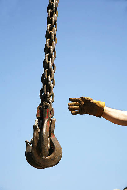 istock Hand of unknown worker with industrial crane chains 620735532