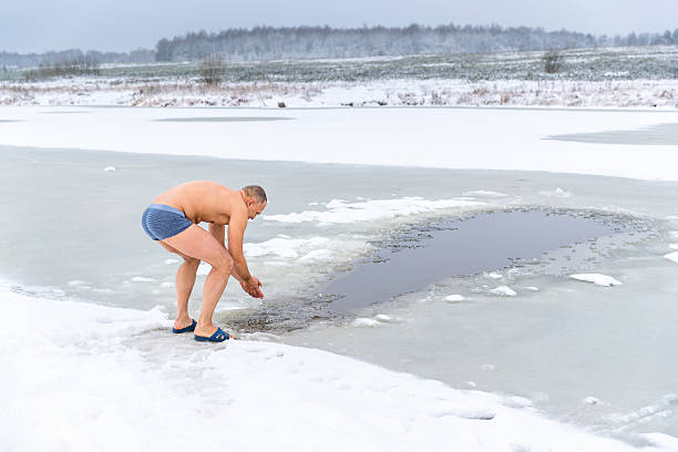 istock Winter swimming. Man in ice-hole 620736906