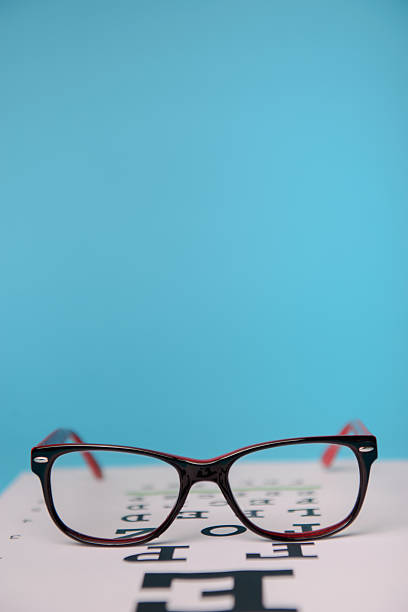 glasses lying on snellen test chart stock photo