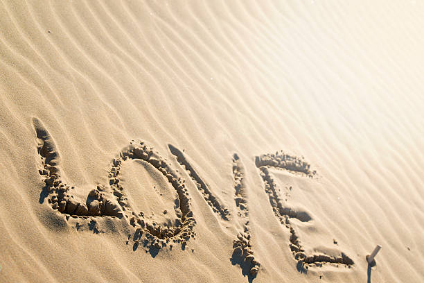 istock word love written on the beach 620737082