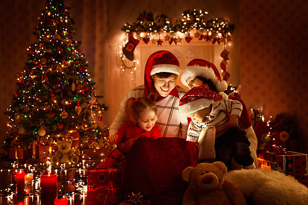 christmas family opening present gift bag, looking light, xmas tree - family christmas imagens e fotografias de stock