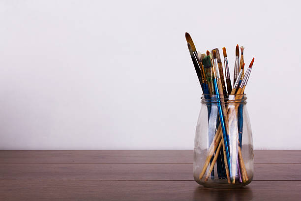 istock Paint brushes in a pot against a white background 620740494