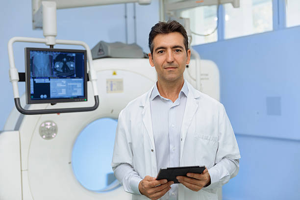 Portrait of a doctor front of a scanner stock photo