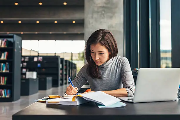 Photo of Female student studying at college library