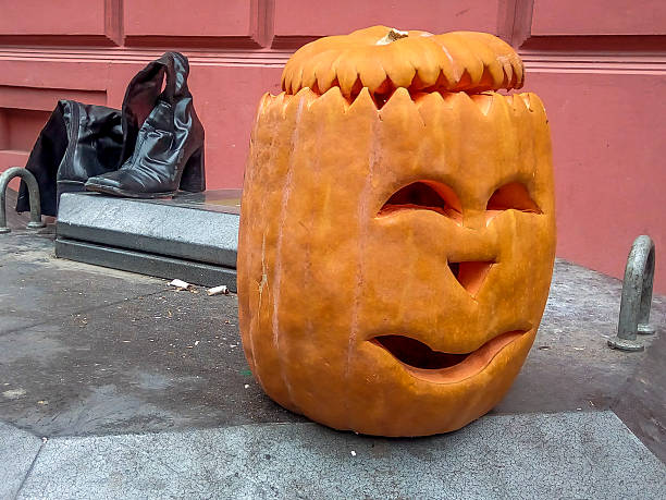 istock Halloween pumpkin on a dump with old shoes 620954112