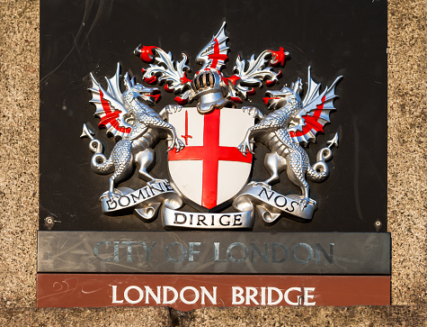London, UK - June 09, 2006: Royal heraldic sign on London Bridge in the summer evening at sunset. 
