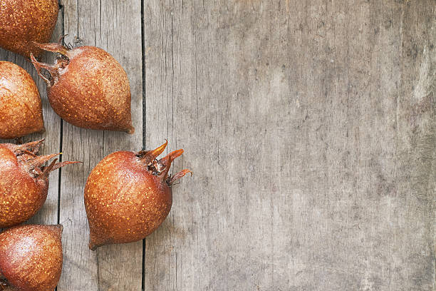 Common medlar fruit mispel Common medlar fruit (mispel) on grey rustic wooden background. Top view with plenty of copy space germanica mespilus mespilus germanica mispel stock pictures, royalty-free photos & images