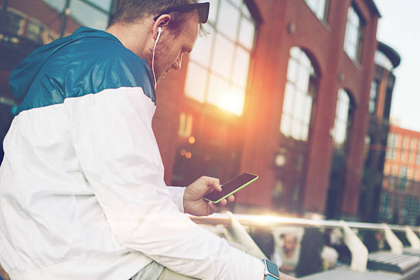 istock Man sitting on the bench with mobile phone 620958084