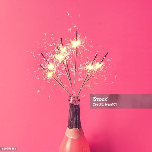 Photo libre de droit de Bouteille De Champagne Avec Cierges Magiques Sur Fond Rose Plat Lay banque d'images et plus d'images libres de droit de Cierge magique