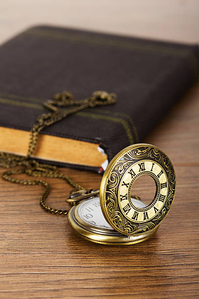istock Pocket watch and book against a rustic background 620959030