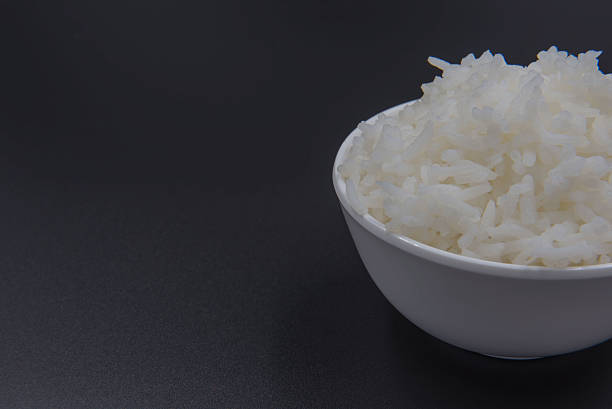 istock Cooked rice in a bowl on a black background. 620959050