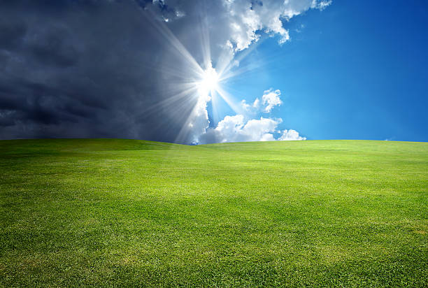 power of nature green landscape over cloudy and sunny sky with sunbeam. light at the end of the tunnel stock pictures, royalty-free photos & images