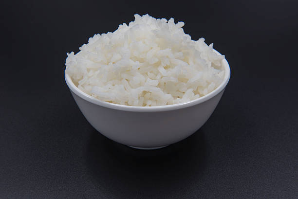 istock Cooked rice in a bowl on a black background. 620959482