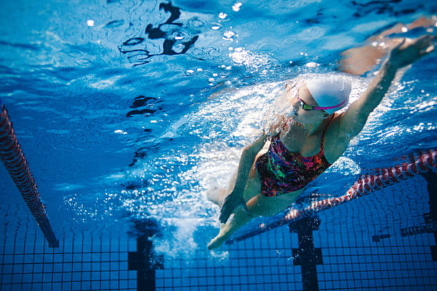 Underwater shot of swimmer training in the pool Underwater shot of fit swimmer training in the pool. Female swimmer inside swimming pool. swimming stock pictures, royalty-free photos & images