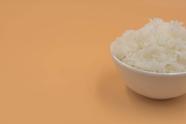 istock Cooked rice in a bowl on a yellow background. 620960434