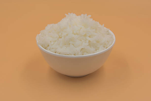 istock Cooked rice in a bowl on a yellow background. 620960510