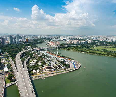 Aerial view of downtown Singapore during a warm day. Singapore River, the Singapore flyer ferris wheel amongst the skyscrapers and highways.