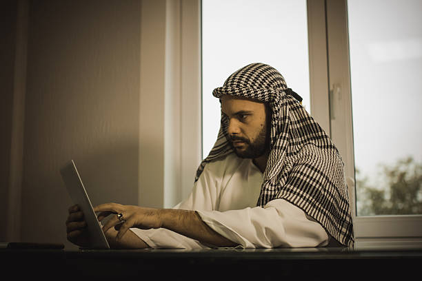 istock Man in dark room looking at tablet 620964890