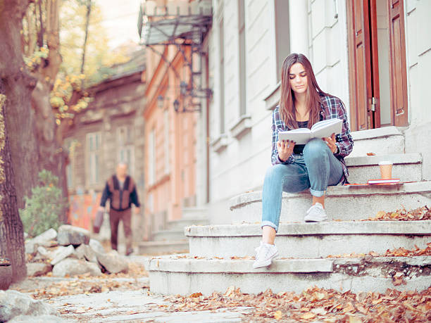 istock Female student at a college entrance checking her notes 620965958