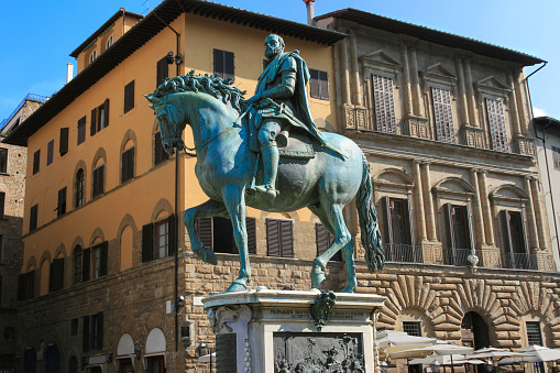 Equestrian Monument of Cosimo I, Piazza della Signoria, Florence, Tuscany, Italy. This bronze equestrian statue was designed by sculptor Giambologna and erected in 1594. Cosimo I de' Medici was the Duke of Florence and the first Grand Duke of Tuscany. Florence is the capital city of the region of Tuscany. It was established by Julius Caesar in 59 BC and was a centre of medieval European trade and finance and one of the wealthiest cities of the time. It was also the birthplace of the Italian Renaissance. Blue sky is in background.