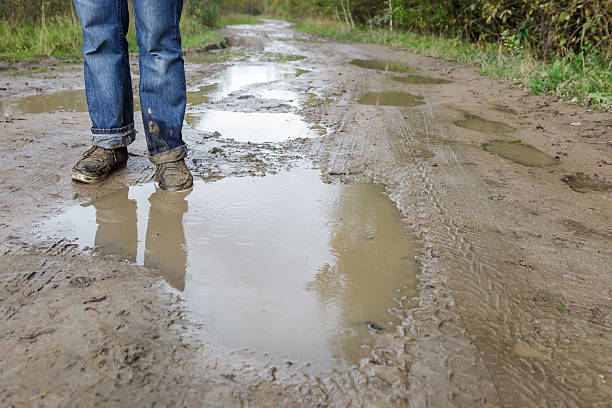 istock Man in dirty shoes standing in the mud 620966894