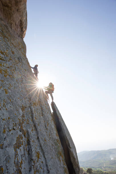 istock Climber belays teammate up steep rock cliff 620969125