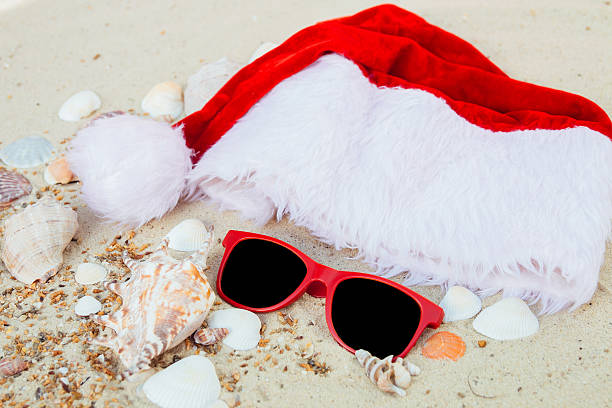 istock Christmas hat and red sunglasses on the beach. Santa 620969602