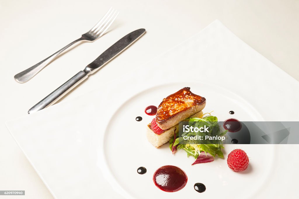 Foie gras on dining table Foie gras in white plate on dining table Dining Table Stock Photo