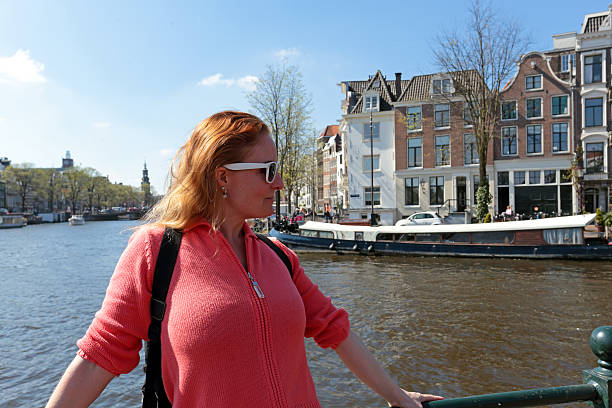 istock Young native dutch woman on a medieval bridge in Amsterdam 620981014