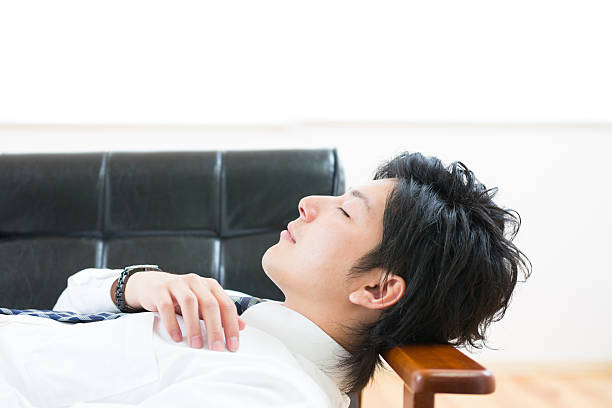 istock Japanese businessman lying down on a sofa 620983630
