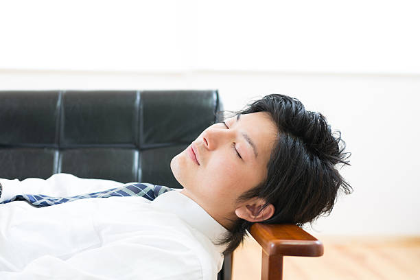 istock Japanese businessman lying down on a sofa 620983670