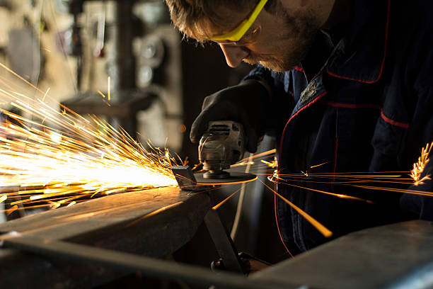 istock Manual worker grinding steel table in production hall. 620983806