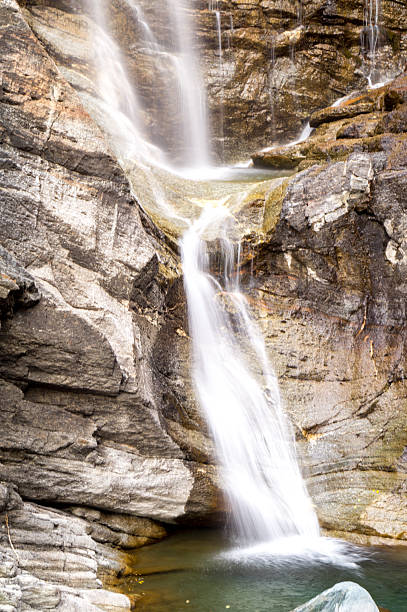 istock waterfall in the mountains and the autumnal trees, long exposure 620983884
