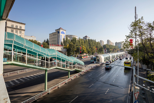 Urumqi, Xinjiang, China - October 10, 2016:BRT station and BRT bus on the left side. Cars are running on the street. 