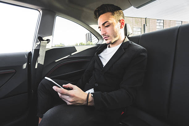 istock fashion man surfing with phone inside a car 620986394