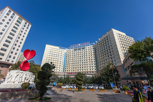 Urumqi, Xinjiang, China- October 10, 2016: Inpatient building of the frist affiliated hospital of Xinjiang Medical University. Incidental people at front.