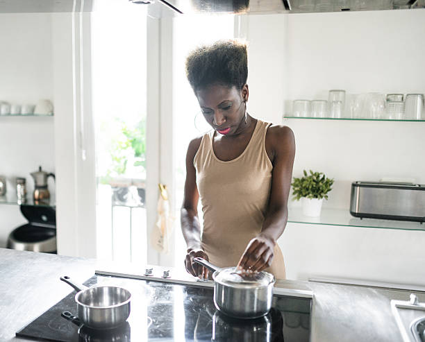 istock afro woman cooking in the kitchen 620989490